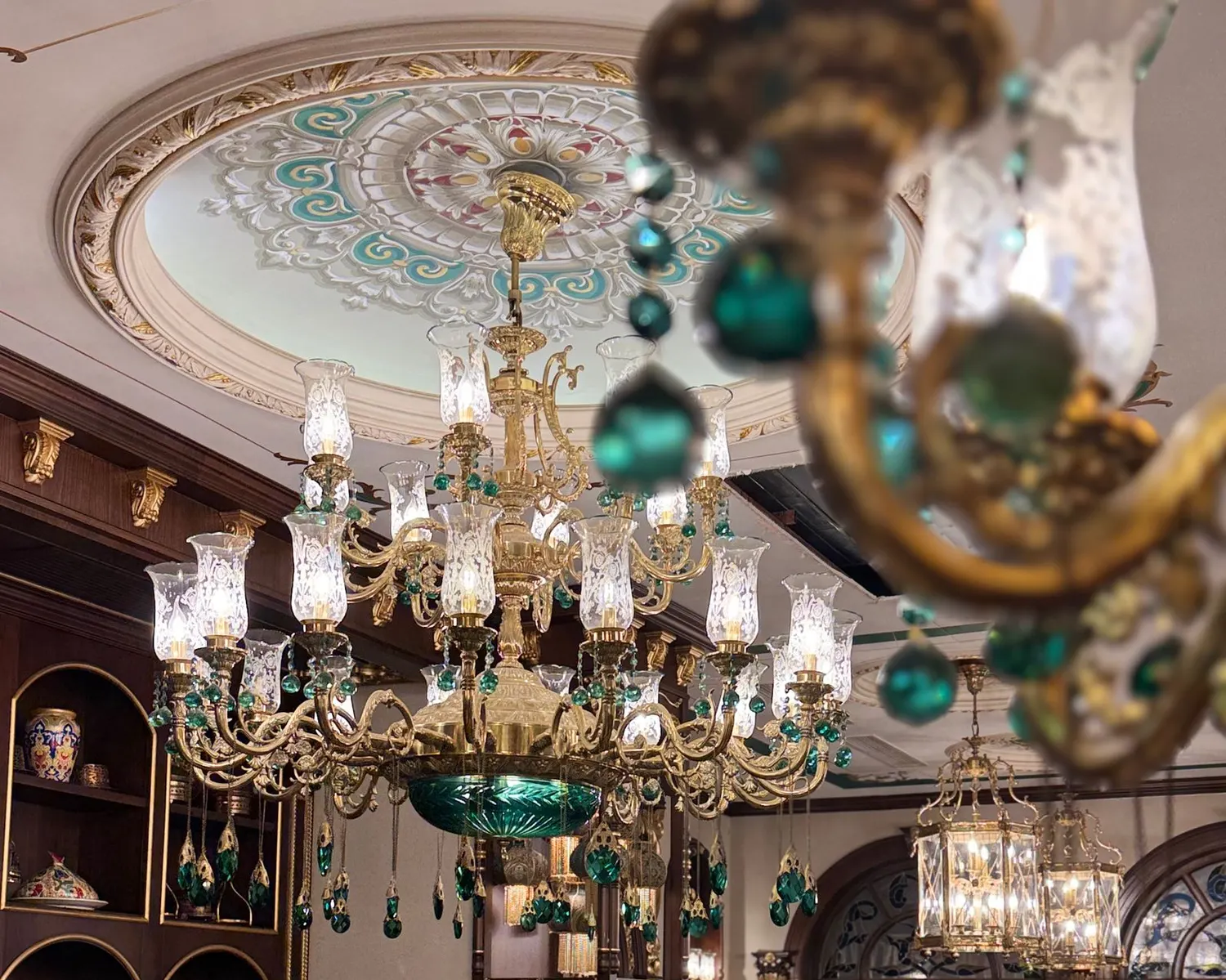 Crystal and emerald glass chandelier under a painted domed ceiling